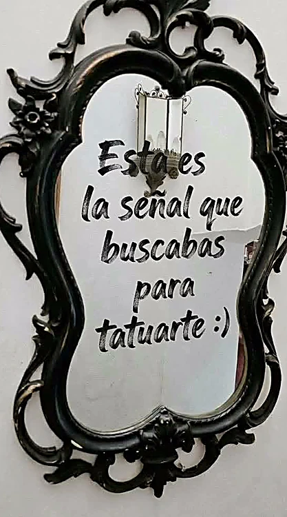 Espejo barroco negro del estudio con la frase escrita: Esta es la señal que buscabas para tatuarte
