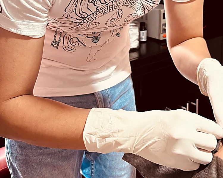 Manos con guantes de nitrilo del perforador de Jauría trabajando en el consultorio del estudio